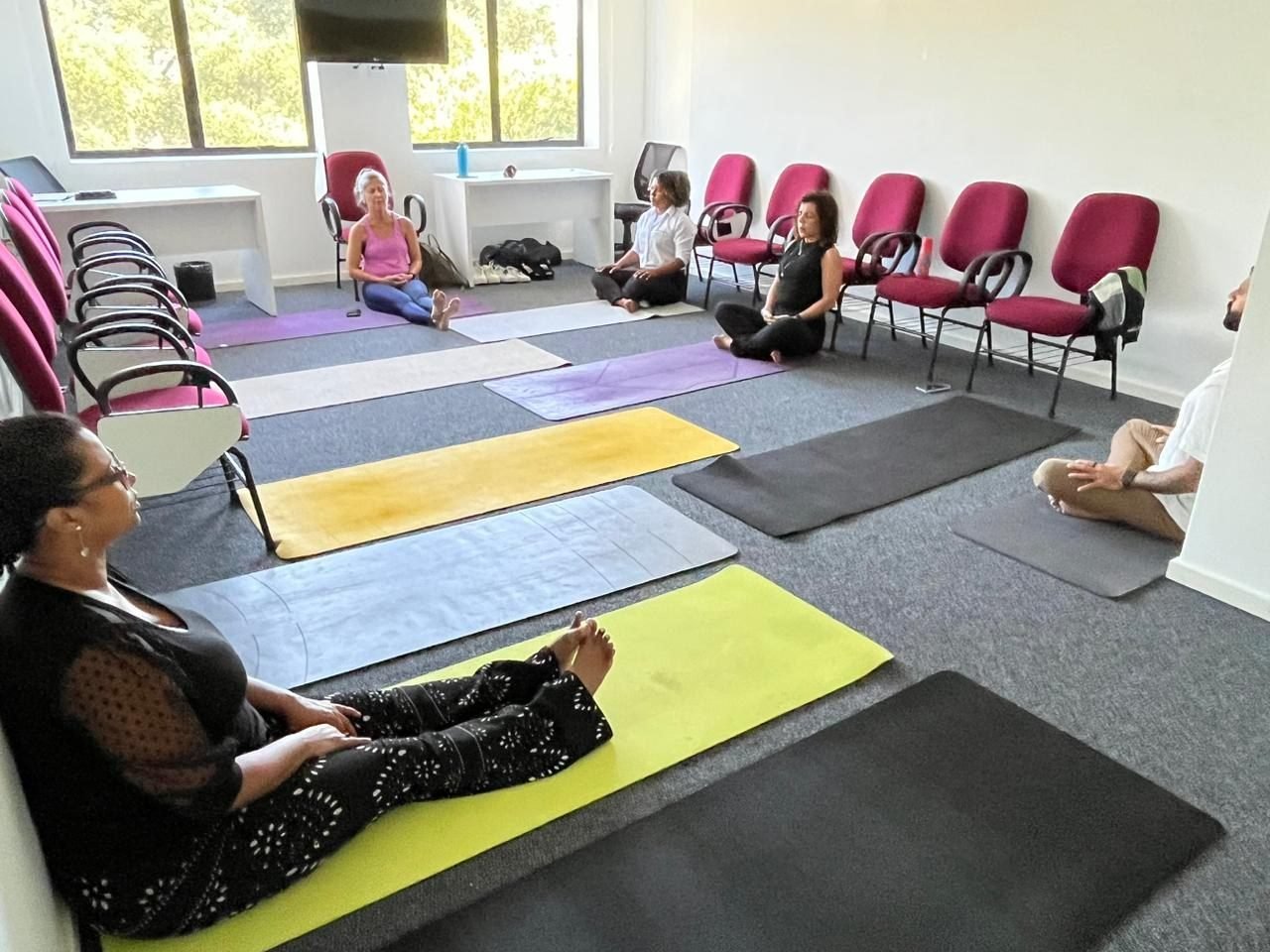 Colaboradores em sessão de ioga laboral e relaxamento no lounge wellness da Zen Viver, no Rio de Janeiro — lounge wellness e ioga laboral para empresas.