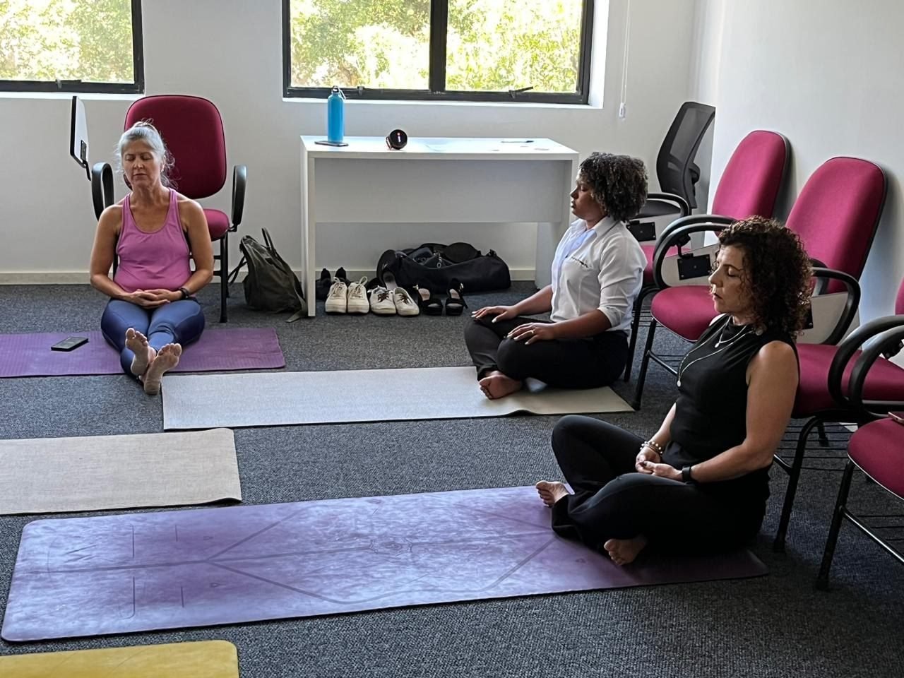 Colaboradores em sessão de ioga laboral e relaxamento no lounge wellness da Zen Viver, no Rio de Janeiro — lounge wellness e ioga laboral para empresas.