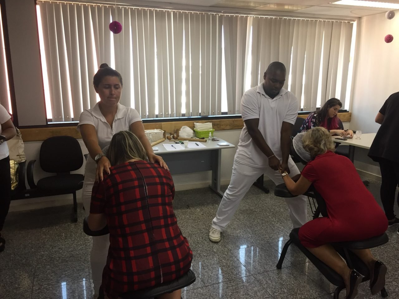 Participantes recebendo quick massage em área de bem-estar durante congresso, no Rio de Janeiro Participantes recebendo quick massage em área de bem-estar durante congresso, no Rio de Janeiro — quick massage para congressos e palestras corporativas.