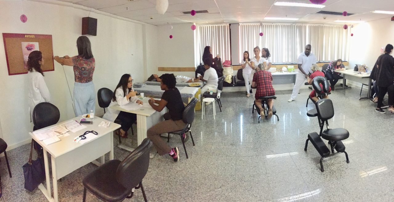 Participantes recebendo quick massage em área de bem-estar durante congresso, no Rio de Janeiro — quick massage para congressos e palestras corporativas.