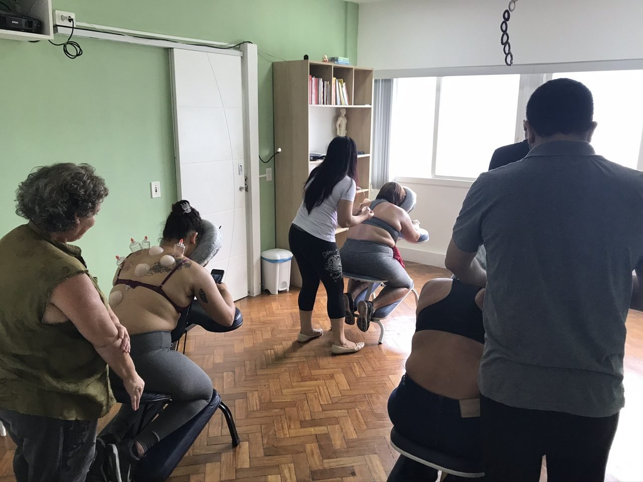 Colaboradores recebendo quick massage em cadeira ergonômica durante evento corporativo, no Rio de Janeiro — serviço de massagem expressa para empresas e SIPAT.