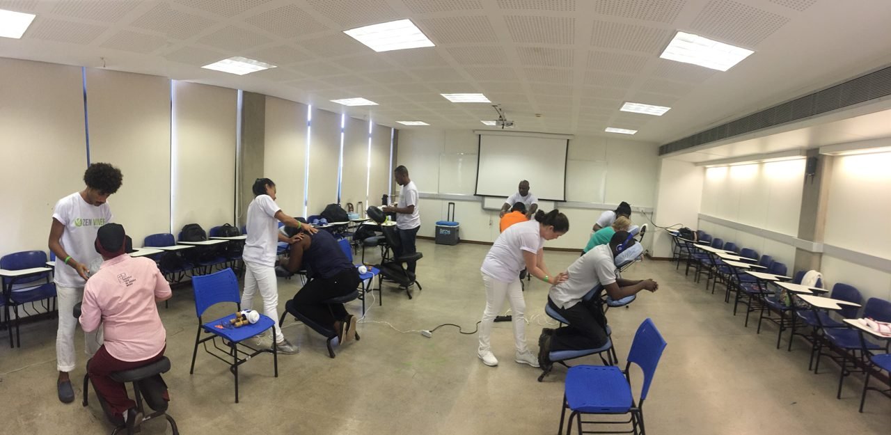 Colaboradores recebendo quick massage em cadeira ergonômica durante evento corporativo, no Rio de Janeiro — serviço de massagem expressa para empresas e SIPAT.