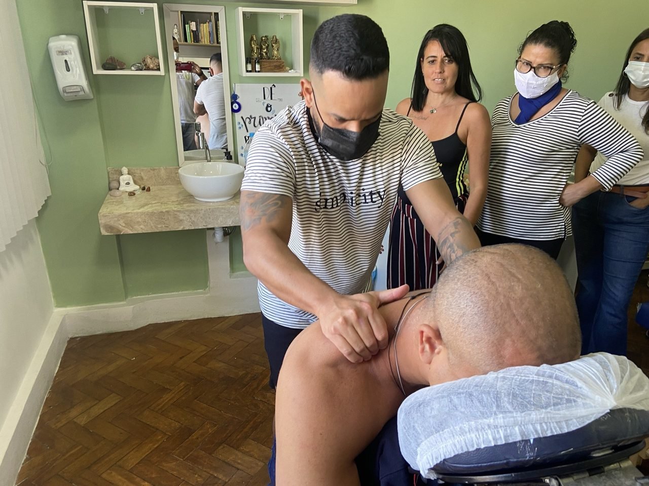 Colaboradores recebendo quick massage em cadeira ergonômica durante evento corporativo, no Rio de Janeiro — serviço de massagem expressa para empresas e SIPAT.