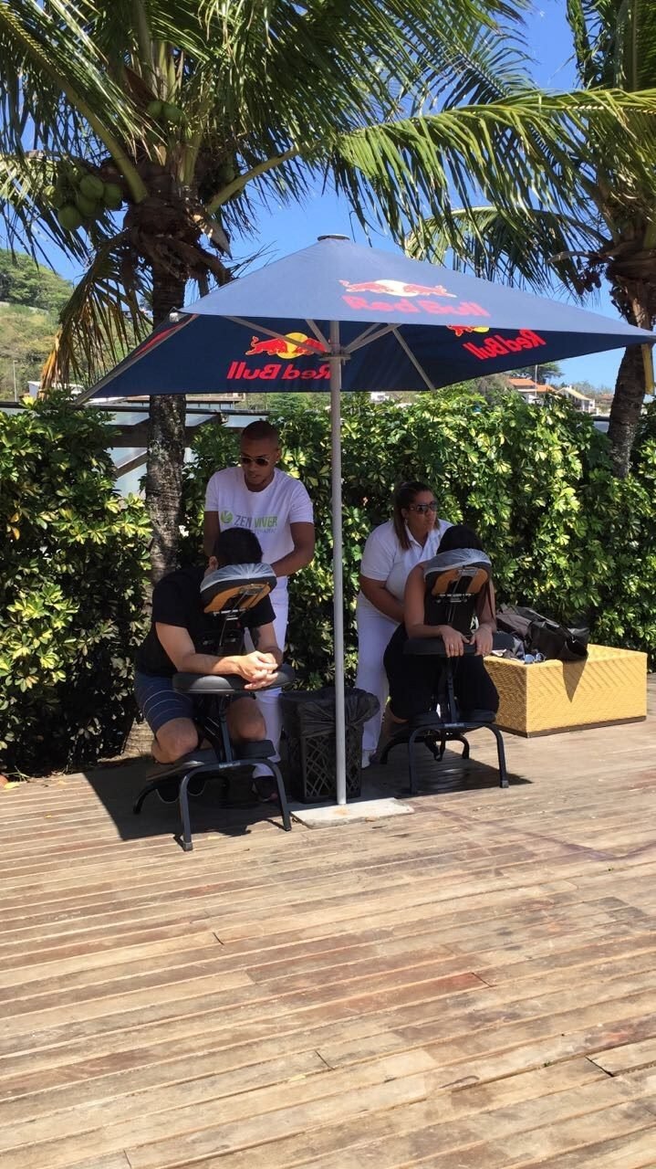 Colaboradores recebendo quick massage em cadeira ergonômica durante evento corporativo, no Rio de Janeiro — serviço de massagem expressa para empresas e SIPAT.