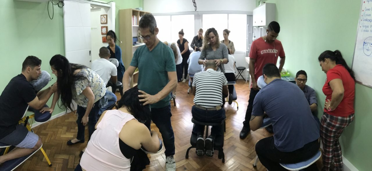 Colaboradores recebendo quick massage em cadeira ergonômica durante evento corporativo, no Rio de Janeiro — serviço de massagem expressa para empresas e SIPAT.