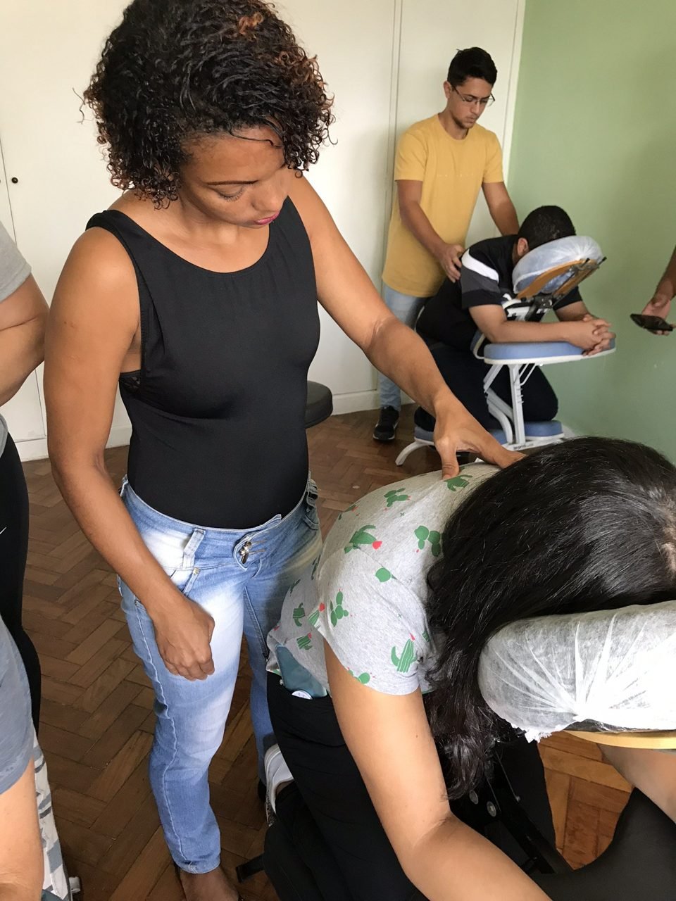 Colaboradores recebendo quick massage em cadeira ergonômica durante evento corporativo, no Rio de Janeiro — serviço de massagem expressa para empresas e SIPAT.