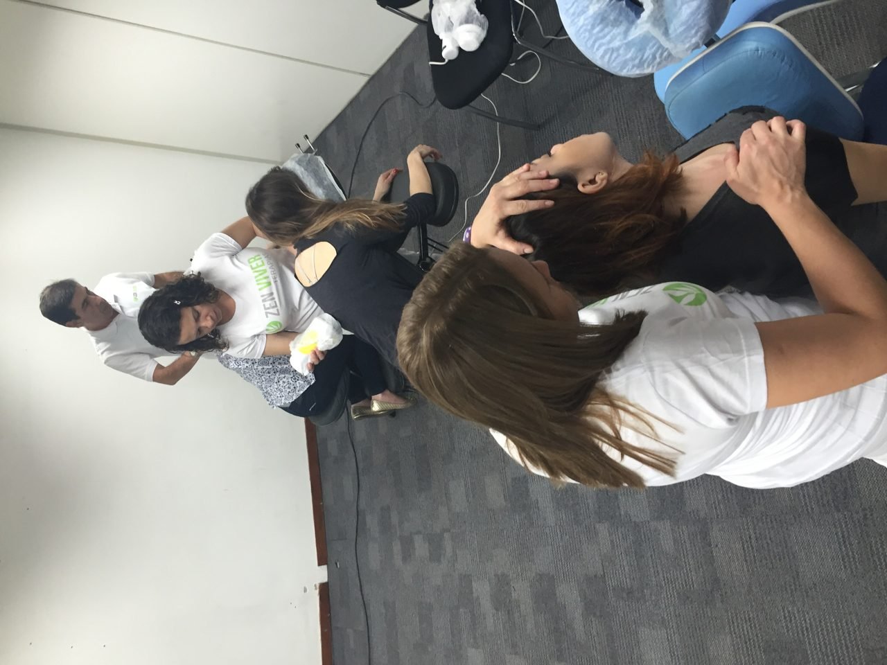 Colaboradores recebendo quick massage em cadeira ergonômica durante evento corporativo, no Rio de Janeiro — serviço de massagem expressa para empresas e SIPAT.